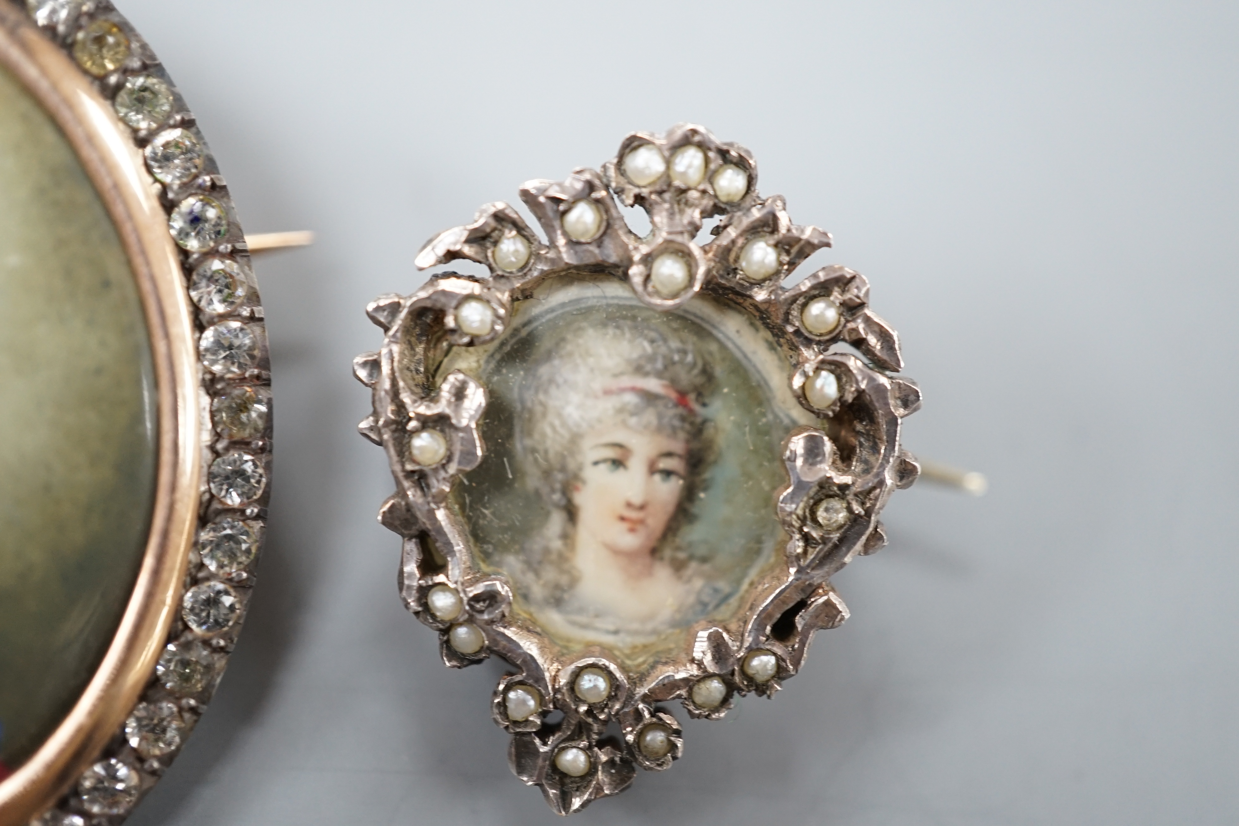 A Victorian yellow and white metal and paste set oval miniature brooch, 41mm and a small circular seed pearl set miniature brooch.